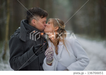Playful Wedding Couple Enjoying Sparklers In Snow Playful Wedding Couple Enjoying Sparklers In Snow 136708851