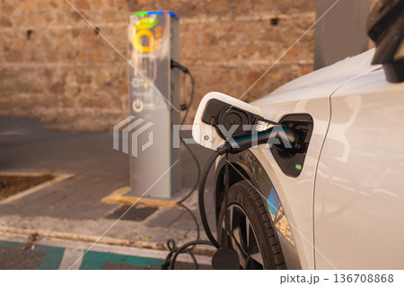 Electric Vehicle Charging at Public Station in Urban Area Electric Vehicle Charging at Public Station in Urban Area 136708868