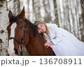 Bride Leaning Affectionately On Horse In Winter Forest 136708911