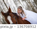 Playful Bride Smiling On Horseback In Snowy Woods 136708912