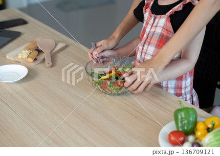 Two women are preparing a salad together Two women are preparing a salad together 136709121