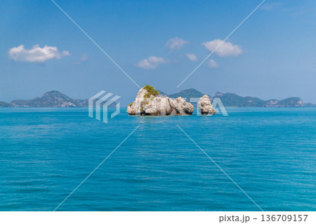 View of limestone islets and turquoise sea in Ang Thong marine park Thailand with calm water blue sky and distant islands creating tropical travel background View of limestone islets and turquoise sea in Ang Thong marine park Thailand with calm water blue sky and distant islands creating tropical travel background 136709157