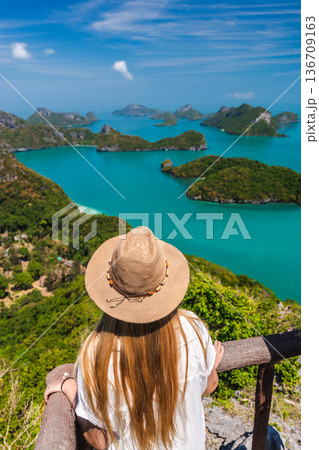 Young woman looking at tropical islands in Angthong National Marine Park from scenic viewpoint 136709163