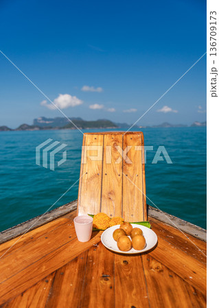 Wooden boat bow with traditional Thai offering on calm blue sea during boat trip to Ang Thong Marine National Park near Koh Samui, Thailand 136709173