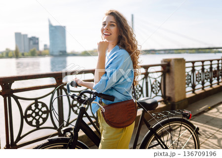 Happy woman riding bicycle bike in the park outdoors. Active urban healthy lifestyle concept Happy woman riding bicycle bike in the park outdoors. Active urban healthy lifestyle concept 136709196