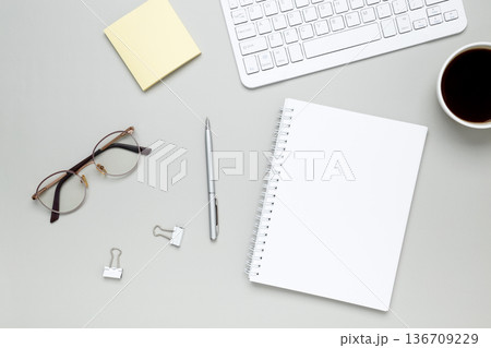 Minimal workspace with coffee cup, glasses and notebook creating calm focused atmosphere 136709229