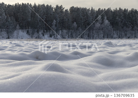 landscape on a river covered with ice and snow after snowfalls, a snow-covered forest in the background, a frozen river in eastern Europe covered with snow landscape on a river covered with ice and snow after snowfalls, a snow-covered forest in the background, a frozen river in eastern Europe covered with snow 136709635