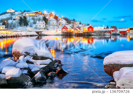 Outstanding evening cityscape of Reine town. Red rorbuers on the shoore of Reinefjorden. Outstanding evening cityscape of Reine town. Red rorbuers on the shoore of Reinefjorden. 136709726