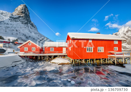 Outstanding winter sunny view on Reine Village and Gravdalbukta bay with cracked ice. Outstanding winter sunny view on Reine Village and Gravdalbukta bay with cracked ice. 136709730
