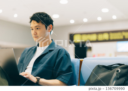 出発時刻まで空港のロビーでパソコンを使う男性　「撮影協力：関西国際空港（KIX）」 136709990
