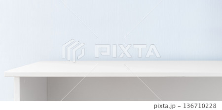 White table against blue wall 136710228