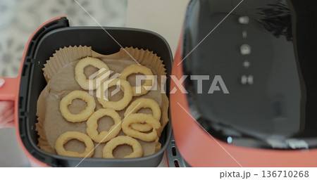 Cooking onion rings in the air fryer. Healthy food for diet eating. Cooking onion rings in the air fryer. Healthy food for diet eating. 136710268