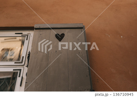 Wooden box with heart shape cutout on brown wall showing simple design in urban area Wooden box with heart shape cutout on brown wall showing simple design in urban area 136710945