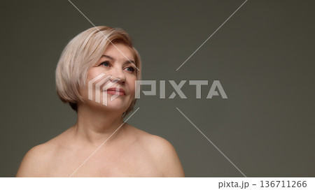 Mature woman looking up natural beauty studio portrait. 136711266