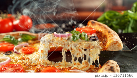 Closeup of a freshly baked pizza with melted cheese and golden crust in warm, appetizing light. Classic comfort food concept with rich texture and inviting presentation. 136711566