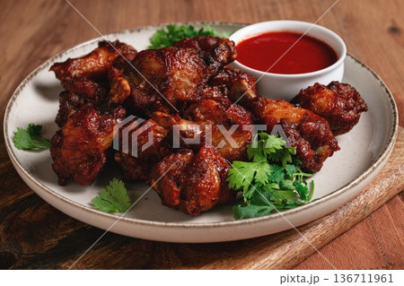 Juicy fried chicken pieces, served with spicy dipping sauce, on a rustic wooden table, Juicy fried chicken pieces, served with spicy dipping sauce, on a rustic wooden table, 136711961