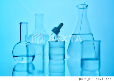 Scientific laboratory glassware filled with blue liquid 136712377