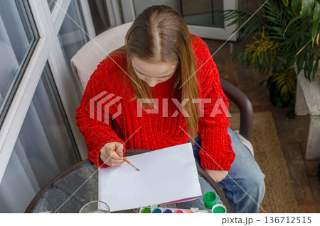 Young child drawing pink cats in a sketchbook. Young preteen girl painting Young child drawing pink cats in a sketchbook. Young preteen girl painting 136712515