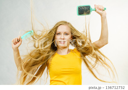 Girl blowing hair with comb brush Girl blowing hair with comb brush 136712732