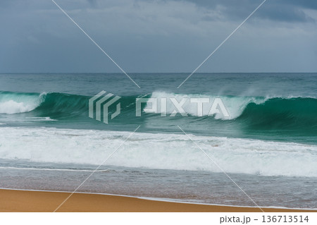 Waves crashing on the sandy beach in Labenne, Landes, France, on a cloudy day. Waves crashing on the sandy beach in Labenne, Landes, France, on a cloudy day. 136713514