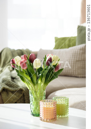 Living Room Decorated Spring Tulip Bouquet in Green Vase and Candles. Cozy Home Decor Arrangement 136713601