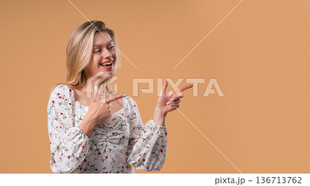 Happy Smiling Woman Presenting And Showing Something Isolated On Beige 136713762