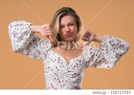 Blonde Woman With Sign Of Dislike. Grimacing Pretty Lady Showing Thumbs-Down Blonde Woman With Sign Of Dislike. Grimacing Pretty Lady Showing Thumbs-Down 136713783