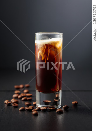 Cream and coffee liquor with ice in tall glass on a black background. Cream and coffee liquor with ice in tall glass on a black background. 136713792