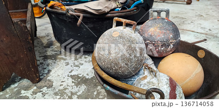 A top view of vintage metal weights on a distressed concrete floor. Concept of storage, recycling, flea market finds, and sports A top view of vintage metal weights on a distressed concrete floor. Concept of storage, recycling, flea market finds, and sports 136714058