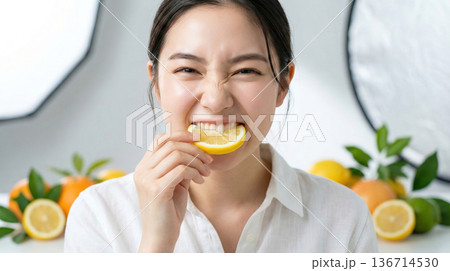 カメラ目線でレモンを一口。酸っぱさに目を細める魅力的な女性 カメラ目線でレモンを一口。酸っぱさに目を細める魅力的な女性 136714530