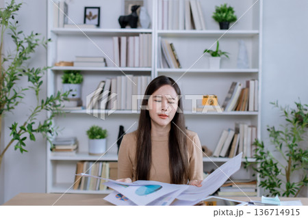 Businesswoman angry throwing papers over the herself in office  136714915