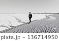 Man Walking Along Frozen Expanse 136714950
