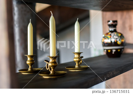 Three brass candlesticks with cream candles and ceramic vase Three brass candlesticks with cream candles and ceramic vase 136715031
