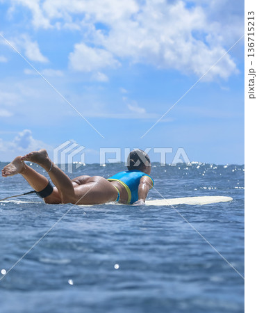 Athletic female surfer Amidst Scattered Clouds From Ocean Perspective 136715213