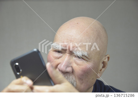 スマートフォンを操作する老人 スマートフォンを操作する老人 136715286