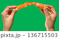 [素材] 日本製の手が緑色の背景に大きな赤いタラバガニの脚を持っています。 136715503