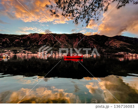 Peaceful village scene with glowing sky and tranquil water 136716083