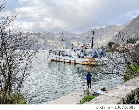 Fishing craft secured at quay with worker checking equipment 136716085