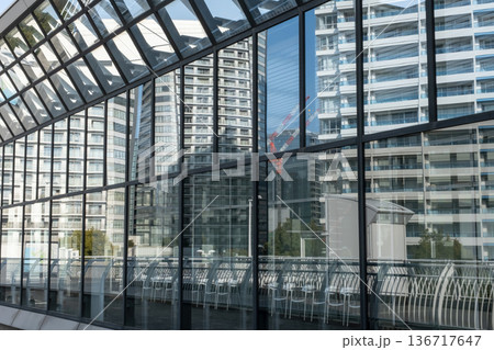 高層ビルのガラスに反射する高層マンション 136717647