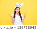 Funny woman with bunny ears celebrate easter on yellow studio background. Bunny girl face. Woman in easter rabbit mask. 136718945