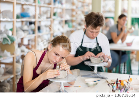 Teenagers are interested in making dishes from clay in pottery workshop 136719314