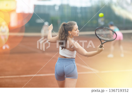 Two young women playing tennis against elderly women Two young women playing tennis against elderly women 136719352