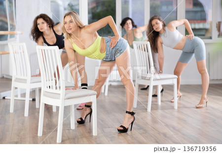 Putting foot hand on seat of chair, girl improvises, perform lap dance during group master class 136719356