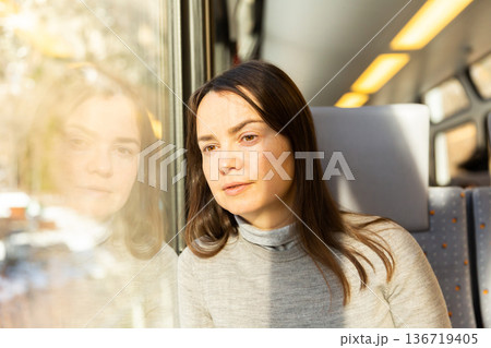 Woman looking through window while traveling by train 136719405