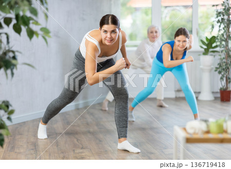 Different ages women learning swing steps at dance class Different ages women learning swing steps at dance class 136719418