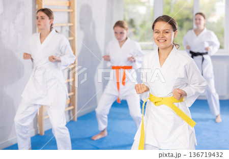 Young female students repeat position and perform sequence of punches and painful techniques kata Young female students repeat position and perform sequence of punches and painful techniques kata 136719432