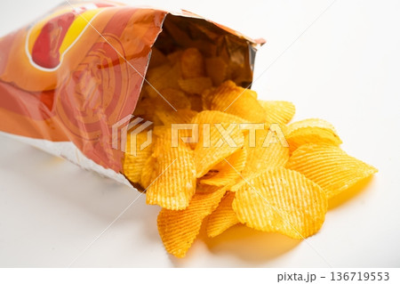 Potato chips, delicious BBQ seasoning spicy for crips, thin slice deep fried snack fast food in open bag. Potato chips, delicious BBQ seasoning spicy for crips, thin slice deep fried snack fast food in open bag. 136719553