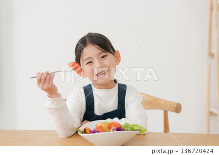 野菜サラダを食べる女の子 136720424