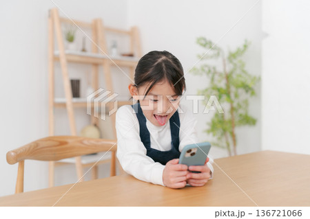 スマホを見る小学生の女の子 136721066