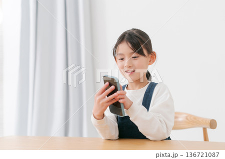 スマホで遊ぶ小学生の女の子 136721087